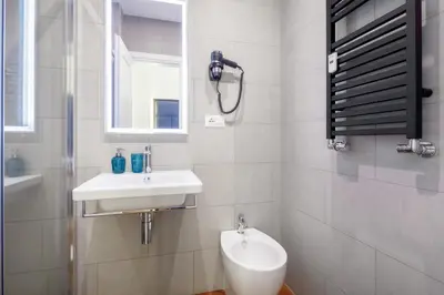 a white bathroom with a sink and a toilet at HT HOMETOWN VITE in Rome