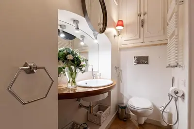 a bathroom with a sink and a toilet and a mirror at Rome As You Feel - Cancelli Apartment in Rome