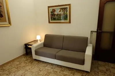 a couch in a room with a picture on the wall at CASA ARIEL in Rome
