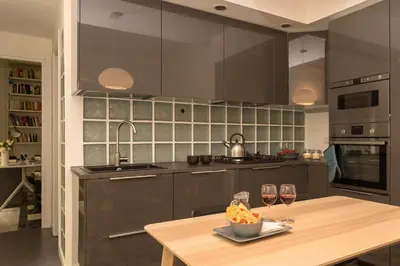 a kitchen with a wooden table and two glasses of wine at Virgiliano Apartment in Rome