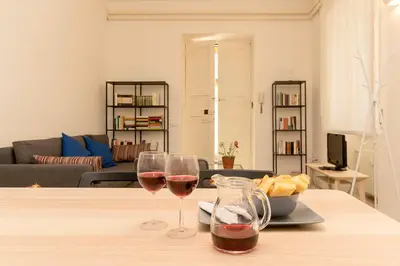 two glasses of wine on a table in a living room at Virgiliano Apartment in Rome