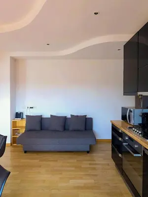 a living room with a blue couch in a kitchen at Panoramic Sunset Terrace Attic in Rome
