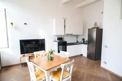 a kitchen and dining room with a table and a refrigerator at COLOSSEUM STREET HoMe in Rome