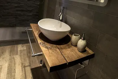 a bathroom with a bowl sink on a wooden counter at Malenki in Rome