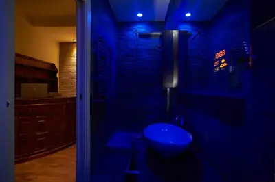 a bluelit bathroom with a sink in a room at Malenki in Rome