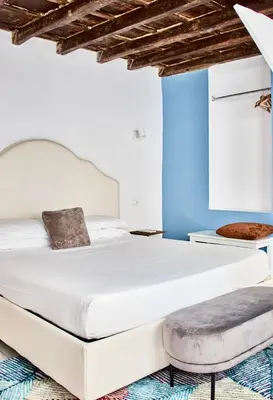 a bedroom with two beds and a stool at Casa Pietra in Rome
