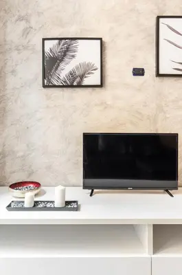 a living room with a tv on a white table at Riari 59 Rome Trastevere - Rome Vacation M&D in Rome