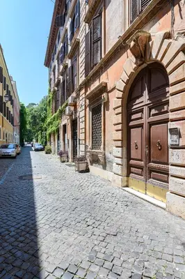 a cobblestone street with a large door on a building at Riari 59 Rome Trastevere - Rome Vacation M&D in Rome