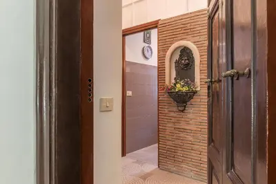 a hallway with a door and a flower pot on a brick wall at GuestHost - Borgo Pio Elegant Apartment! in Rome