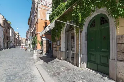 a green door on a building on a street at GuestHost - Borgo Pio Elegant Apartment! in Rome
