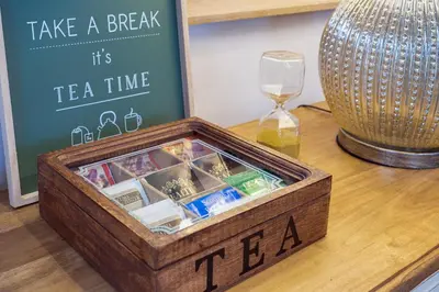a wooden tea crate with a clock and a wine glass at One & Only Buonarroti Suite in Rome