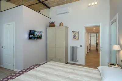 a bedroom with a bed and a cabinet and a hallway at One & Only Buonarroti Suite in Rome