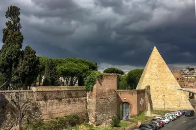 an old building with a pyramid and cars parked at LUMINOSA VISTA PIRAMIDE in Rome