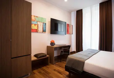 a hotel room with a bed and a desk at Rome Art Hotel - Gruppo Trevi Hotels in Rome