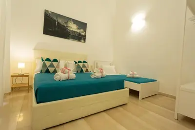 a bedroom with a bed with blue sheets and pillows at San Peter Dill House in Rome