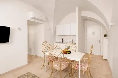 a kitchen and dining room with a white table and chairs at Divo Apartments - Spanish Steps in Rome