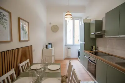 a kitchen with a table and chairs and a kitchen with a counter at SWEET DREAM CAVOUR in Rome