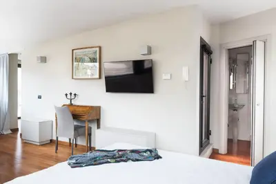 a bedroom with a bed and a desk with a television at Idyllia - Penthouse in Navona Area in Rome