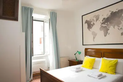 a bedroom with a bed with yellow pillows and a window at St.Peter flat in Rome