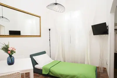 a room with a bed and a table and a mirror at St.Peter flat in Rome