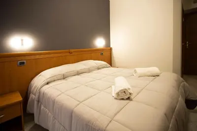 a bedroom with a white bed with towels on it at AFFITTACAMERE ROMANSTYLE in Rome