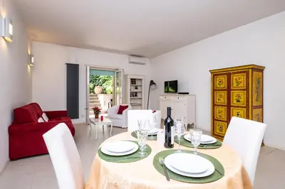 a dining room with a table and a red couch at Vatican Quiet Apartment with Garden & Parking in Rome