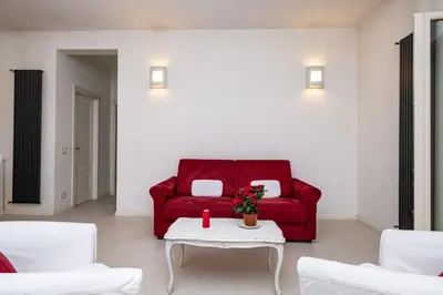 a living room with a red couch and a table at Vatican Quiet Apartment with Garden & Parking in Rome