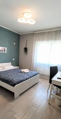 a bedroom with a bed and a table and a window at Pretty Tiburtina Room in Rome