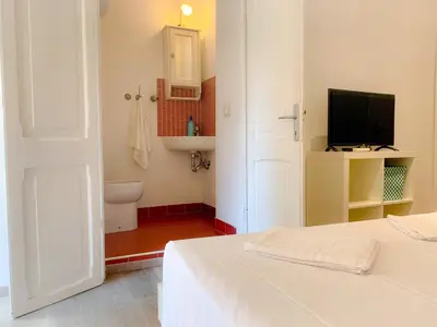 a white room with a bed and a television at Luxury barberini boutique Apartment in Rome
