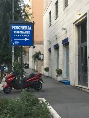 a scooter parked next to a sign on a street at Il Faro Gianicolense in Rome
