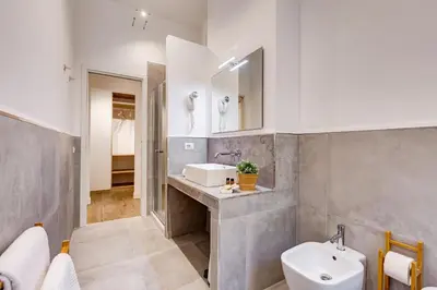 a bathroom with a sink and a toilet and a mirror at Germanico Luxury Apartment in Rome