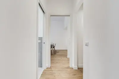 an empty hallway with white walls and wood floors at Germanico Luxury Apartment in Rome