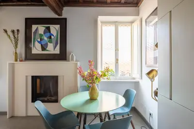 a dining room with a table and chairs and a fireplace at Monti Exclusive Medieval Tower in Rome