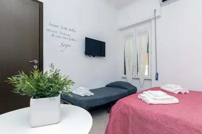 a room with a table and a couch and a tv at Il Cortiletto di Via Tuscolana in Rome