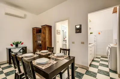 a dining room with a table and chairs and a refrigerator at Popolo accommodation - Lovely Central apartment in Rome