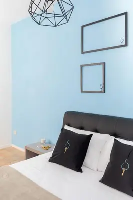 a bedroom with a bed and a black leather chair at A World Aparts - 13 T.Argentina in Rome