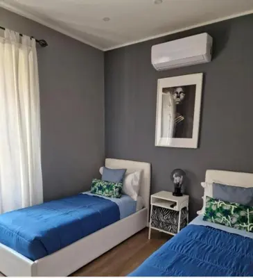 two beds in a bedroom with blue and white at Homey in Rome