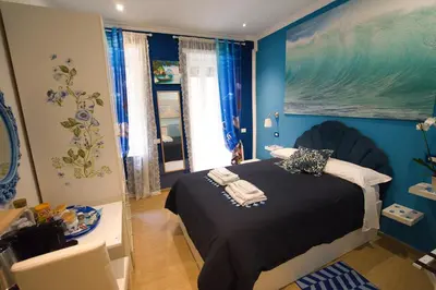 a bedroom with a bed with a blue wall at Etere in Prati Rooms in Rome