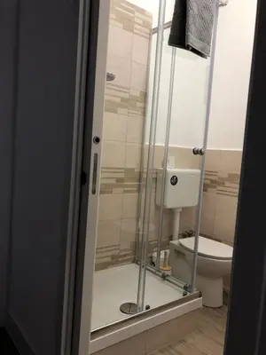 a bathroom with a glass shower with a toilet at B&B Da Ponticello in Rome