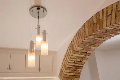 a chandelier hangs from a white ceiling in a kitchen at Vatican Studio Apartment in Rome