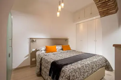 a bedroom with a bed with two orange pillows at Vatican Studio Apartment in Rome