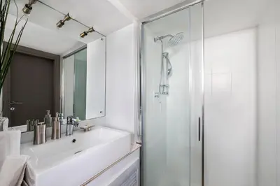 a white bathroom with a sink and a shower at iFlat Trastevere Bianca's House in Rome