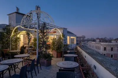 a patio with tables and chairs on a roof at Antica Dimora Delle Cinque Lune in Rome