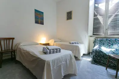 a room with two beds and a chair and a window at old corallo in Rome