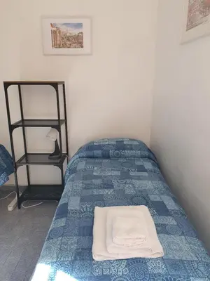 a bedroom with a bed with a blue and white bedspread at old corallo in Rome