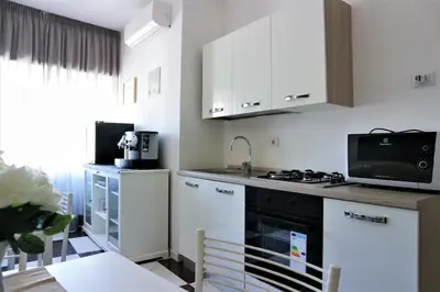 a kitchen with white cabinets and a black stove top oven at Luxury Vatican Rooms in Rome