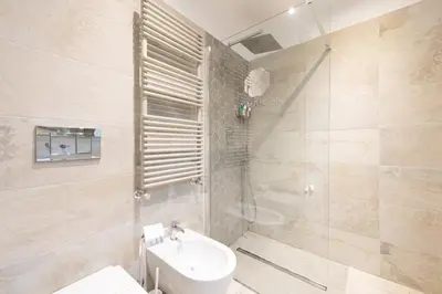 a bathroom with a shower and a toilet and a sink at La Maison di Sant'Anna in Rome