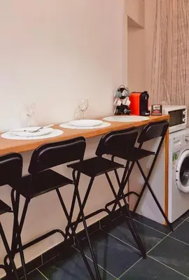 a kitchen with a counter with two chairs and a microwave at AMP Vatican House in Rome