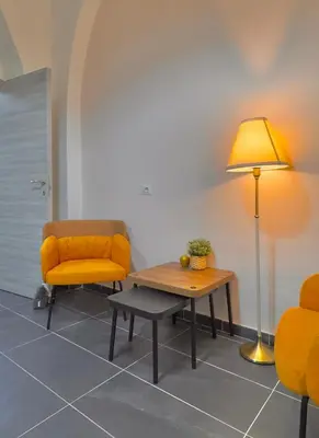 a living room with a chair and a table and a lamp at AMP Vatican House in Rome