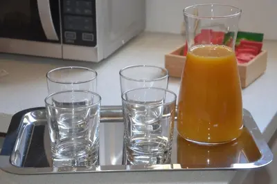 three glasses of orange juice sitting on a tray at Colosseum relax family apartament in Rome